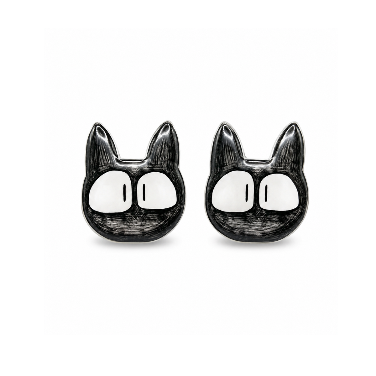 A pair of black and white cartoon cat face titanium stud earrings on a plain white background.