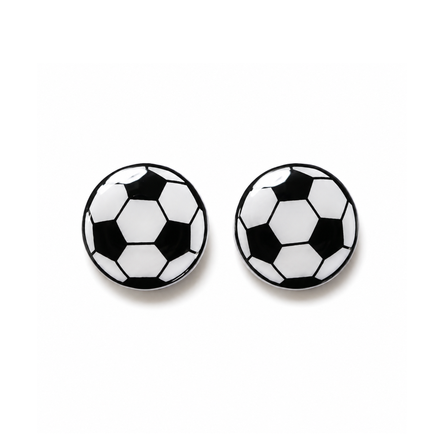 A pair of round stud earrings designed like classic black and white soccer balls, shown on a clean white background.