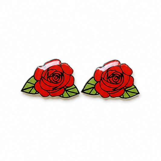 A pair of rose-shaped stud earrings featuring vibrant red roses with green leaves and black outlines, set against a plain white background.