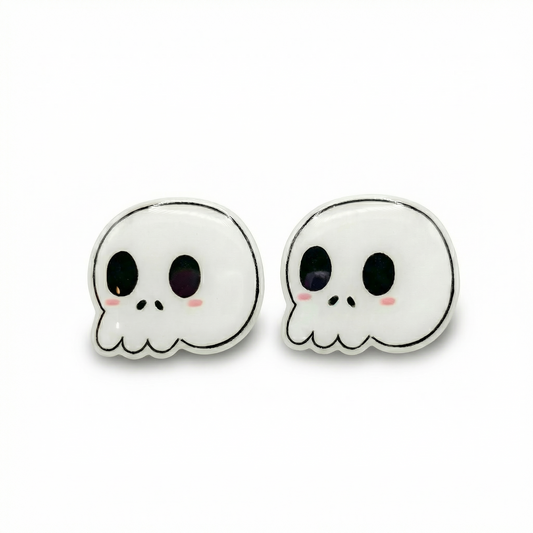 Pair of skull-shaped earrings with black eyes and pink cheeks on a white background
